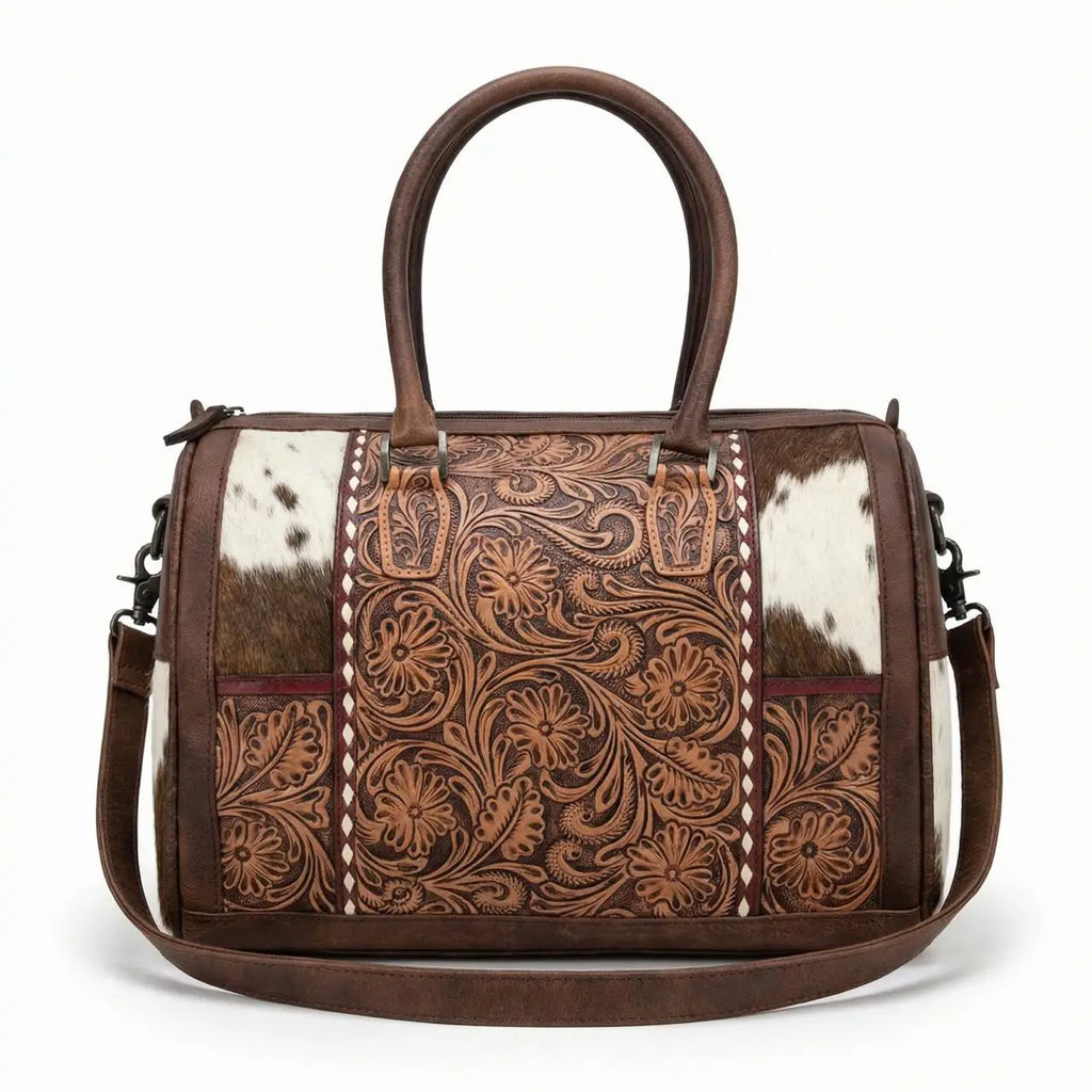 Brown leather mini duffel bag with floral tooling, cowhide panels, top handles, and a detachable shoulder strap.