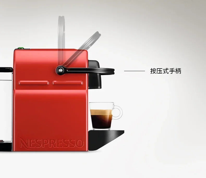 Bright red Nespresso coffee machine with black lever handle and espresso glass on a white background.