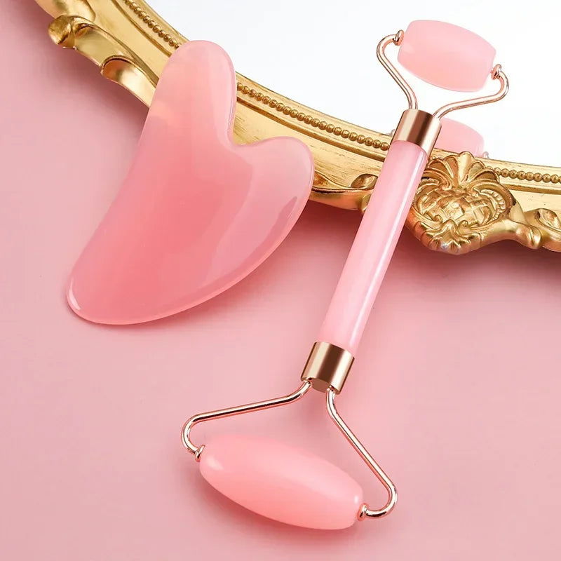 Pink resin jade facial roller and heart-shaped gua sha scraper set for anti-aging skin massage and face lifting.