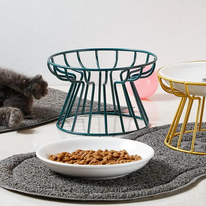 Raised ceramic cat and dog bowls with green and gold metal stands for ergonomic feeding and comfortable dining.