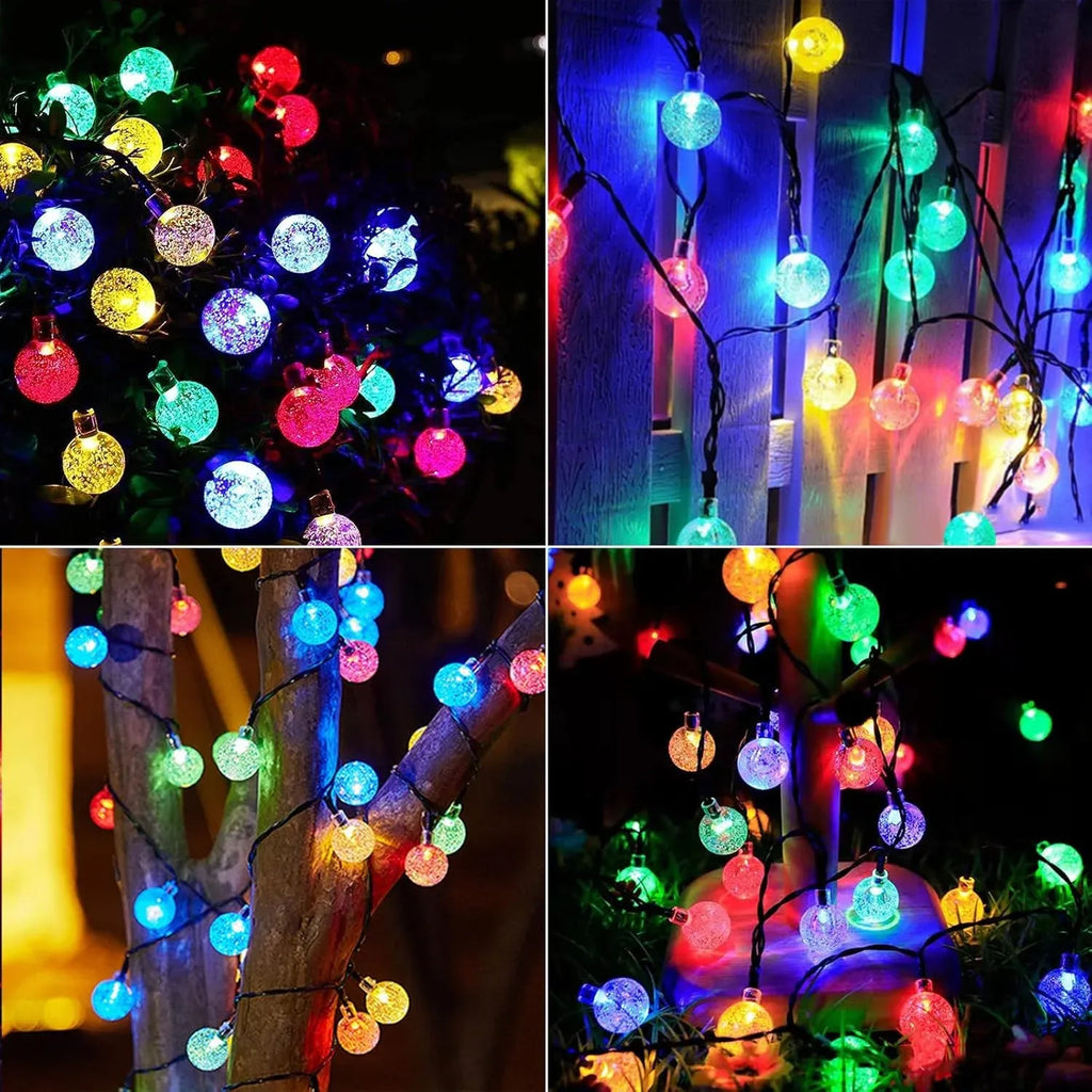 Multicolor LED globe string lights with glowing round bulbs on trees and fence lines.