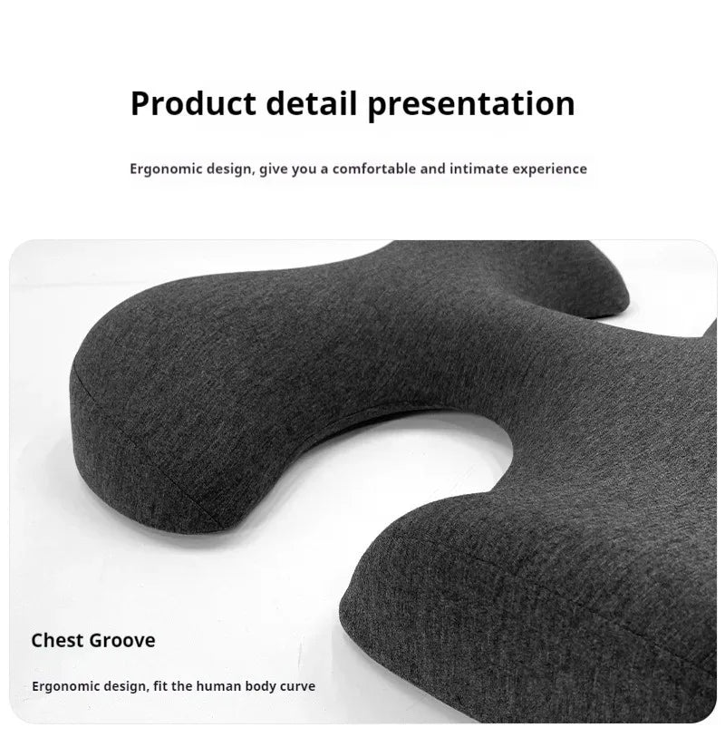 Grey, ergonomic salon massage pillow with a curved, U-shaped design for chest support, made of soft fabric.