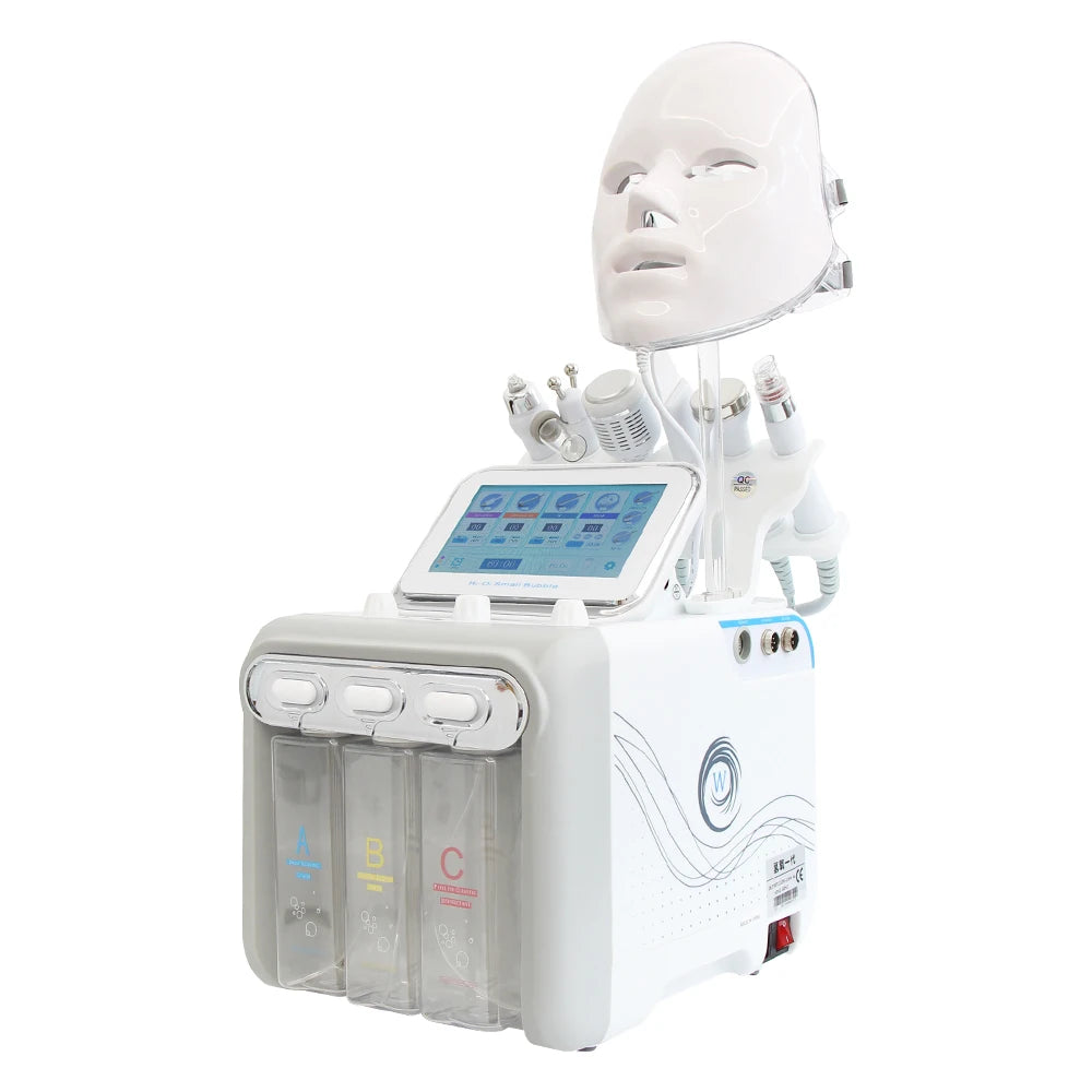 White 7-in-1 hydro dermabrasion facial machine with LED mask, touch screen, and three solution tanks for skin care.