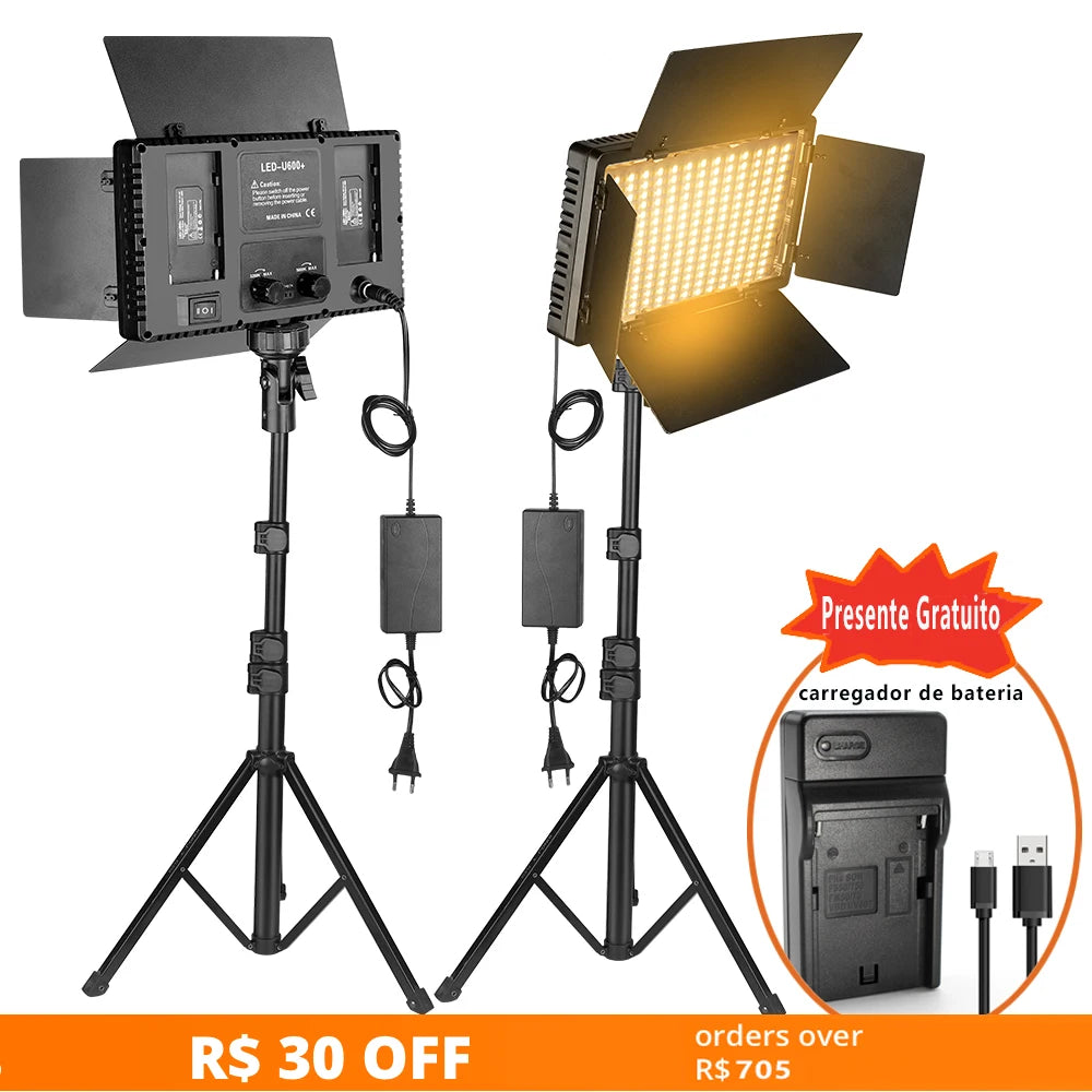 Two LED light panels with barn doors on adjustable tripod stands, power adapters, and a battery charger.