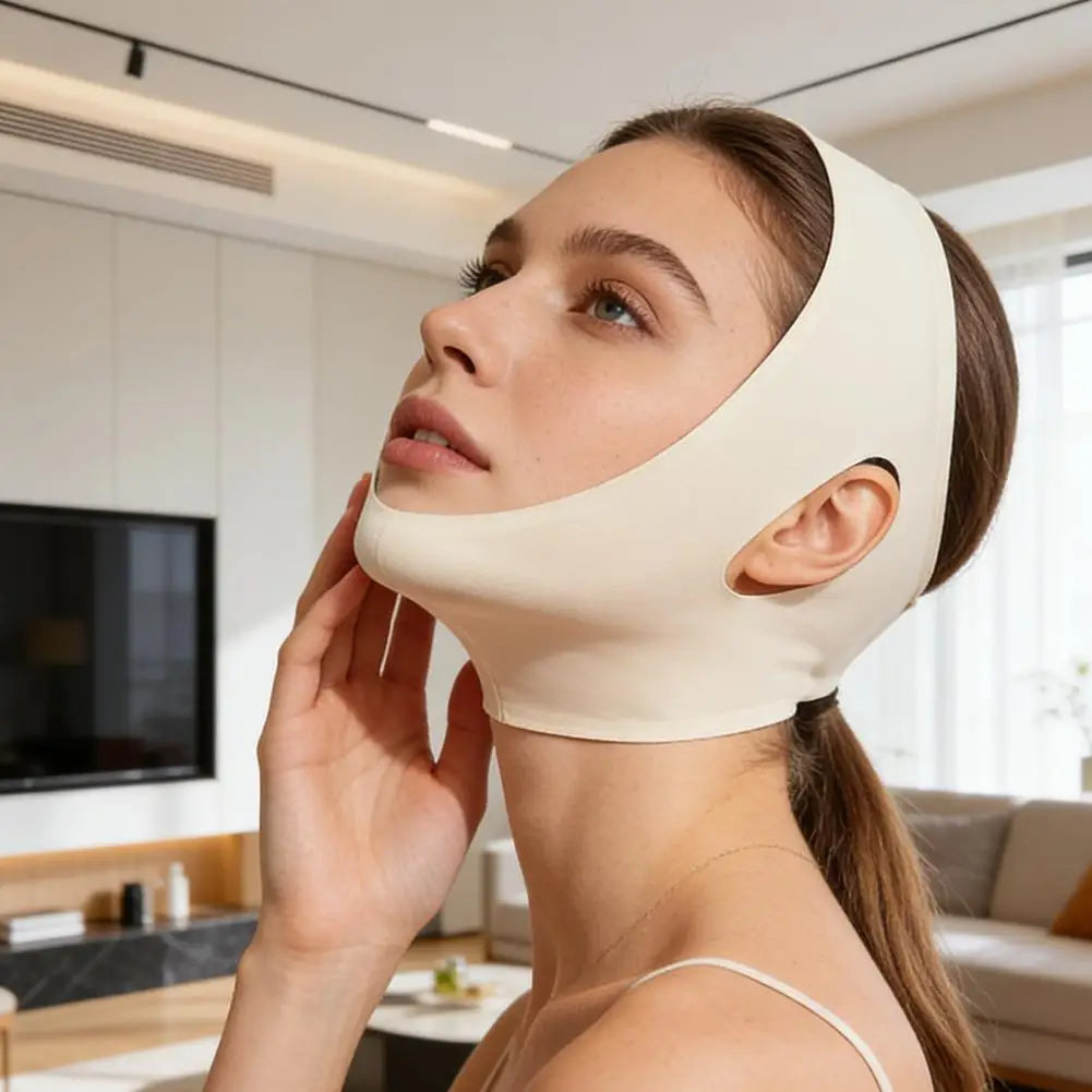 A woman wearing a beige, soft fabric V-line face slimming bandage with ear cutouts to lift the chin and jawline.