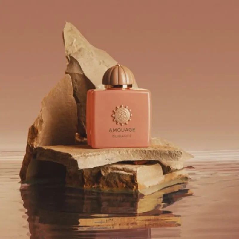 Amouage Guidance 46 Women's EDP: elegant peach square bottle with round cap, warm feminine scent on decorative rocks.