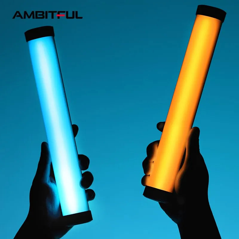 Two hands holding cylindrical LED light wands, one glowing blue and one glowing orange for photography lighting.