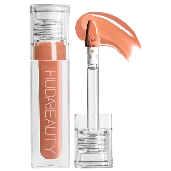 Huda Beauty hydrating peach lip and cheek tint in a clear tube with doe-foot applicator and creamy swatch.