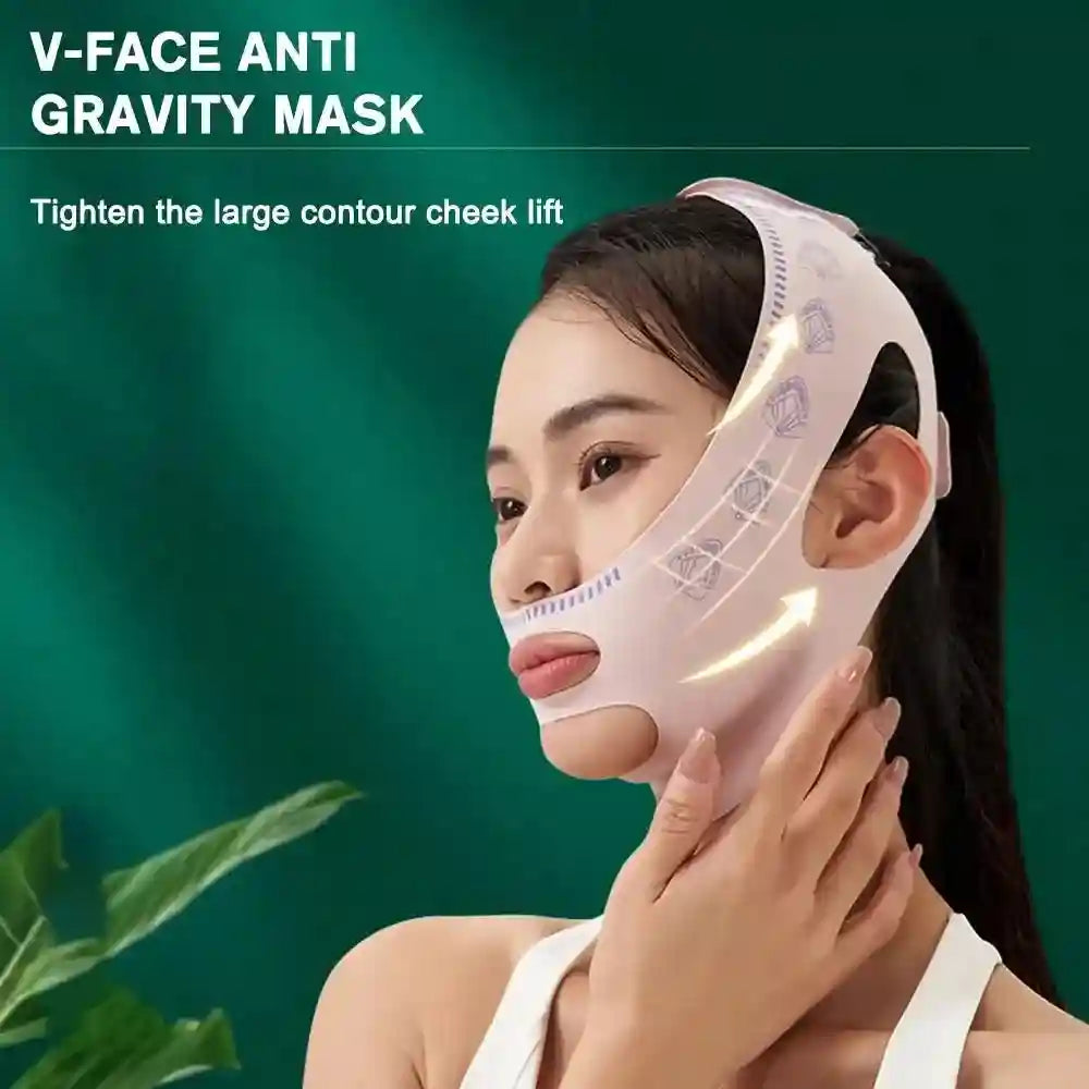A person wears a light pink, fabric V-line facial lifting mask with cutouts for the ears and chin against a dark green.