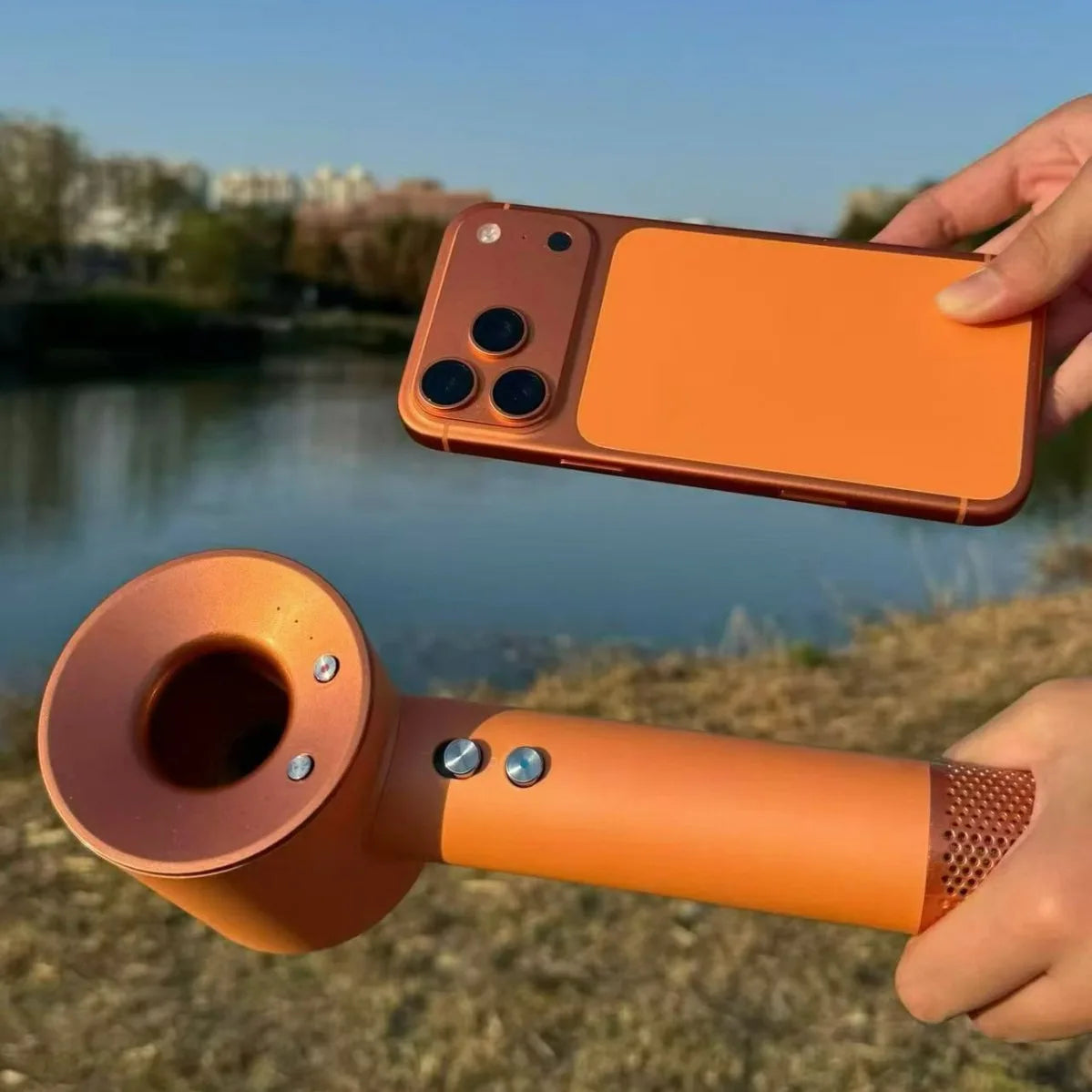 Orange high-speed bladeless negative ion hair dryer with magnetic attachments and sleek metallic finish.