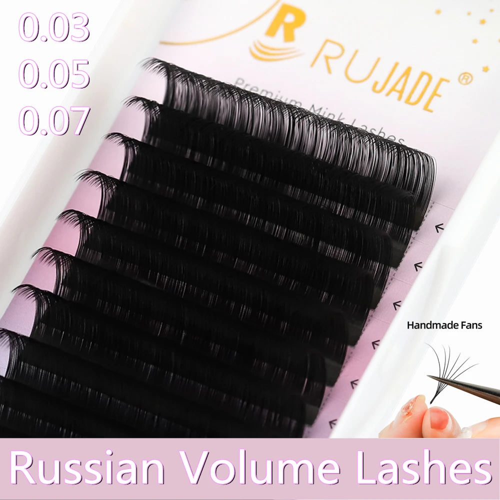 Tray of black Rujade Russian Volume eyelash extension strips with a hand demonstrating a single handmade silk lash fan.