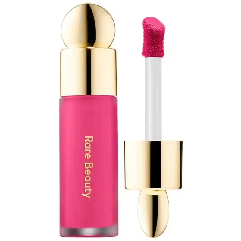 Rare Beauty matte liquid lipstick in vibrant hot pink with gold cap and soft-touch applicator. Rich, smooth texture.