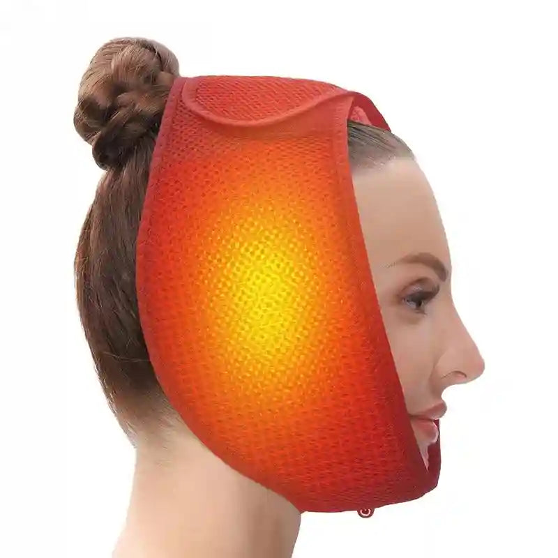 A woman wears a bright orange, mesh-textured electric jaw heating pad secured over her head with Velcro straps.