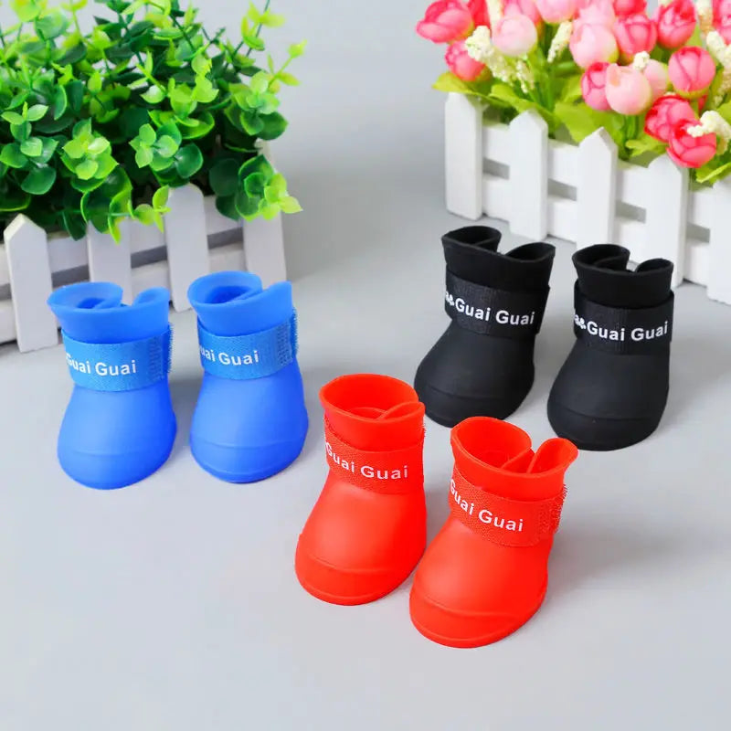 Waterproof, non-slip silicone rain boots for dogs and cats in blue, black, and red for outdoor paw protection.