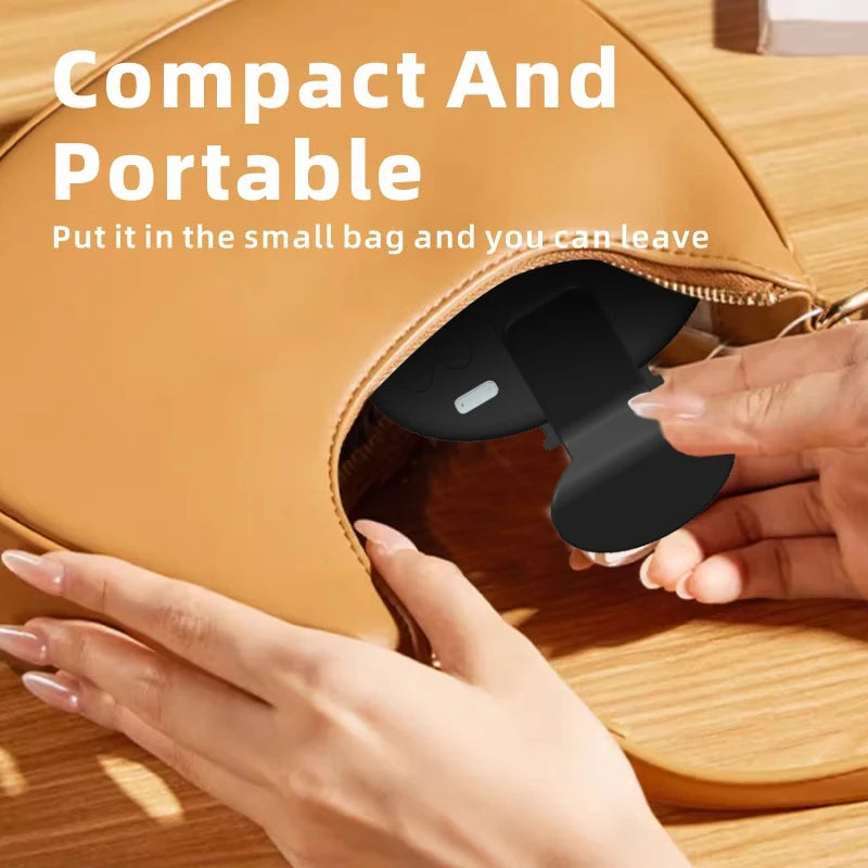 Small black folding UV nail lamp being placed into a tan leather handbag.