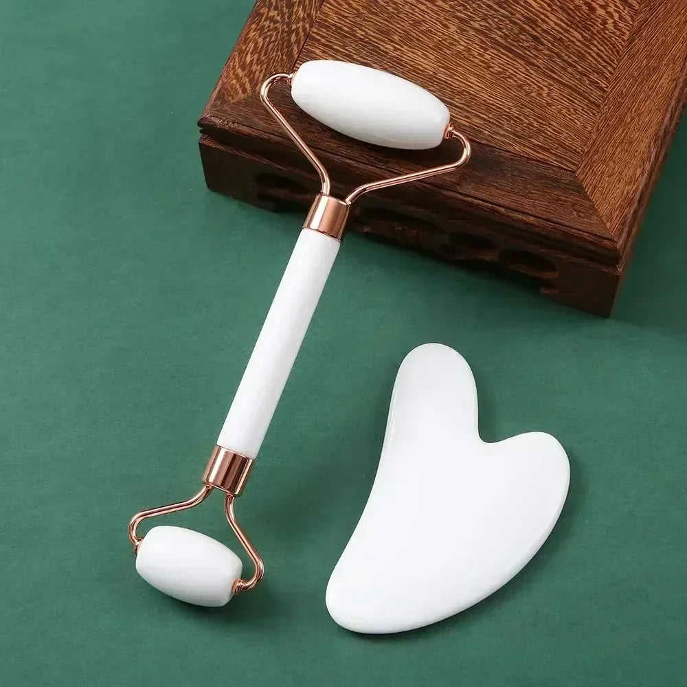 White resin facial roller and heart-shaped gua sha scraper set for anti-wrinkle massage and facial lifting.