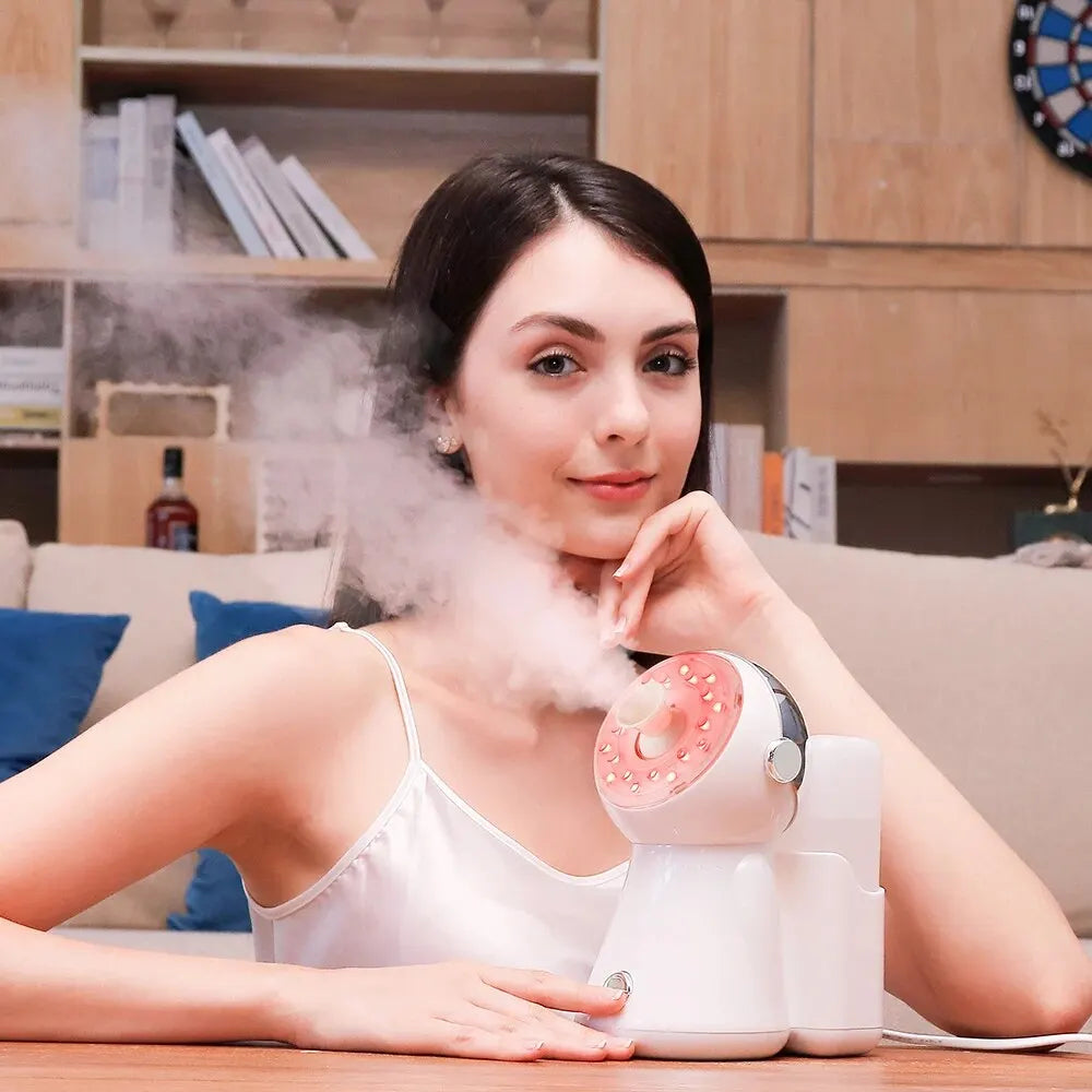 White and pink facial steamer emitting mist, compact tabletop design for skin hydration.