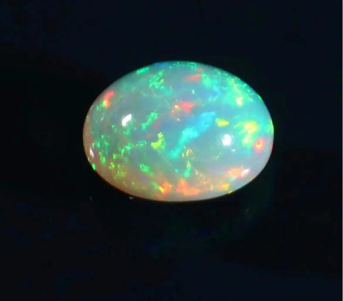 Oval opal cabochon with strong green play-of-color and warm orange sparks.