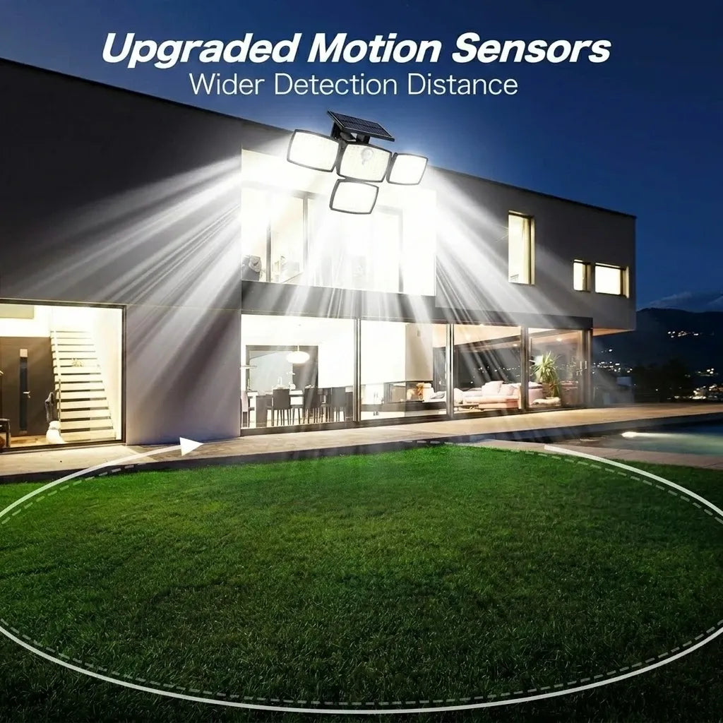 Black four-head solar flood lamp mounted on a modern house exterior, casting bright light outward at night.