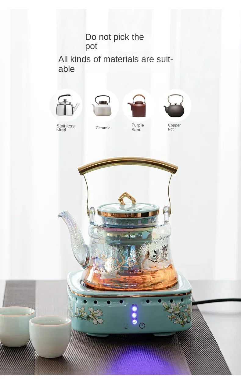 Iridescent glass tea kettle on a floral ceramic electric stove with gold handle, suitable for various teapot types.