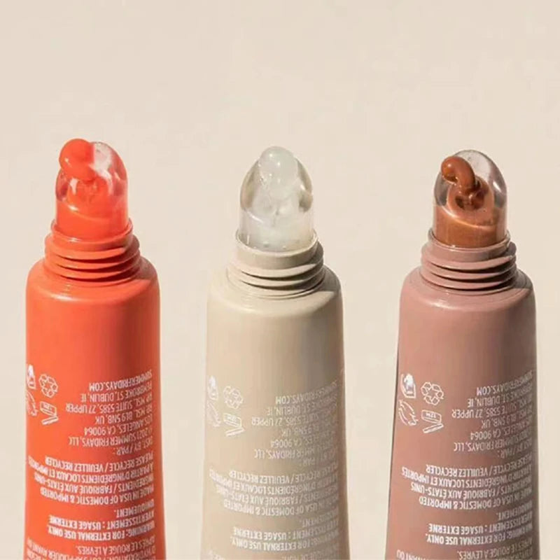 Three Summer Fridays moisturizing lip balm tubes in orange, clear, and beige with smooth, glossy, mirror-like texture.