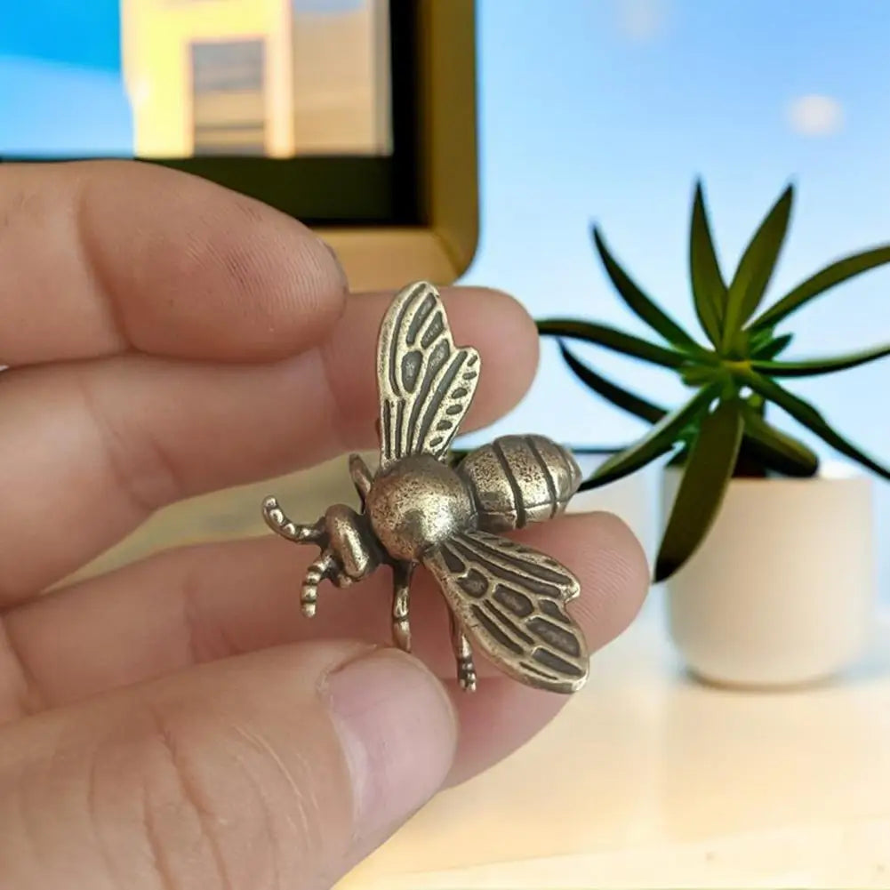 Small realistic golden brass bee tea pet figurine held in hand, perfect for desk decoration or collectible ornament.