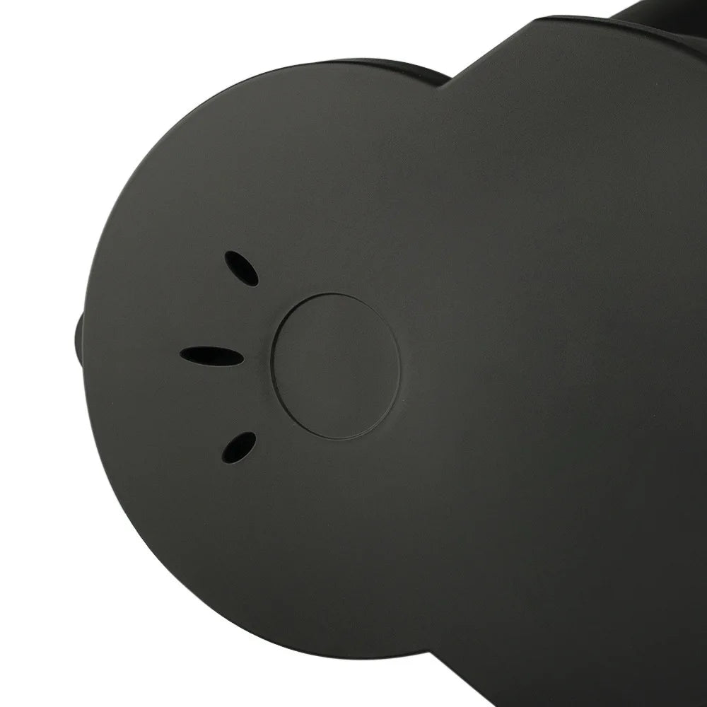 Matte black lid of a modern electric kettle with steam vent holes and central button detail.