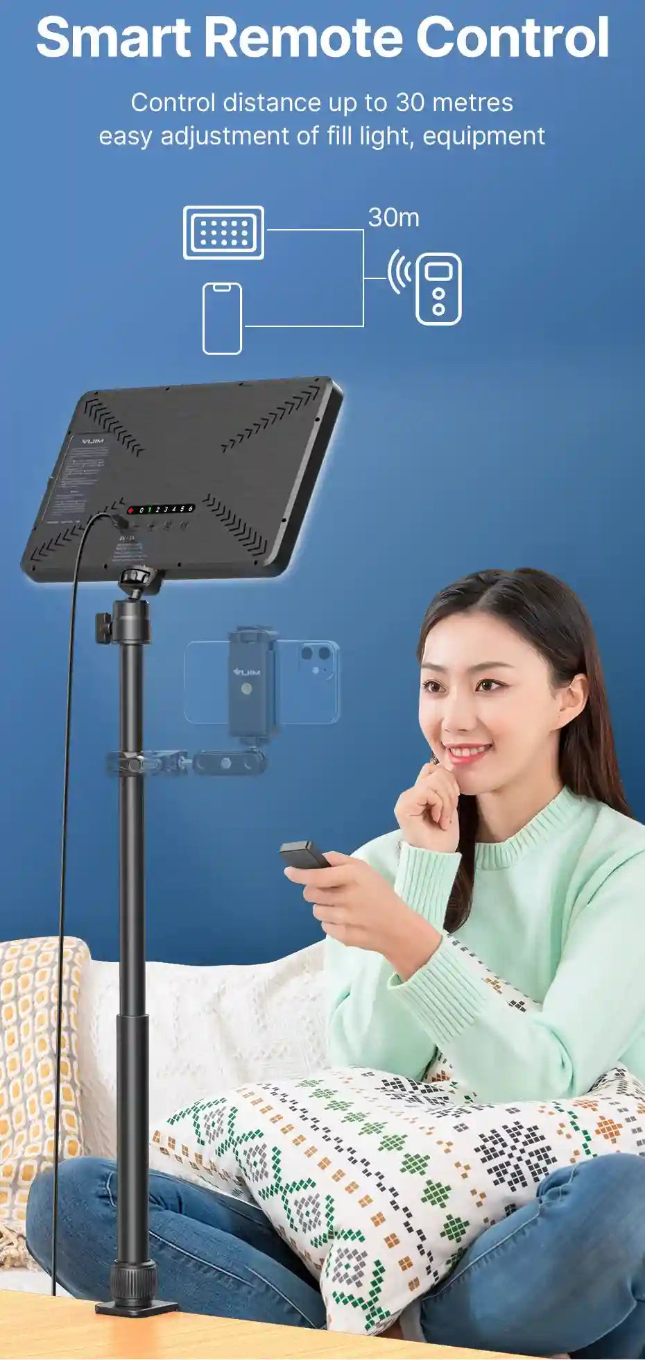 Black rectangular wireless remote control used to adjust a tall tripod-mounted LED panel light for photography.