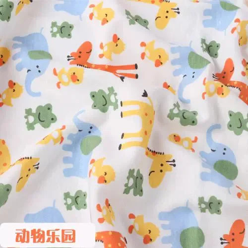 Tidesmit white knit jersey fabric featuring a colorful print of cute giraffes, elephants, ducks, and frogs.