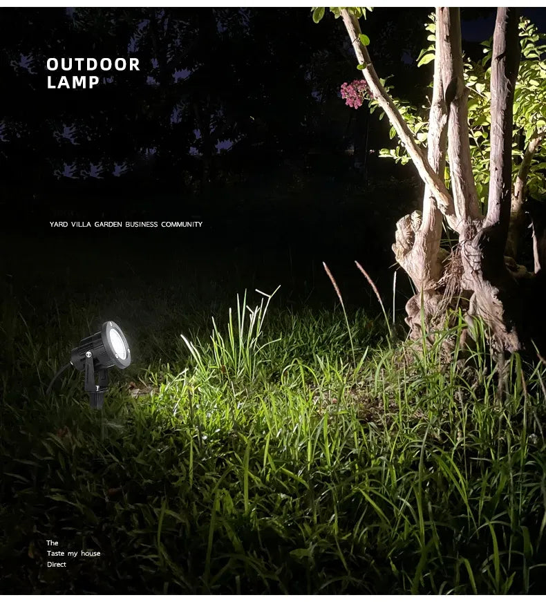 Two outdoor LED spike lights in a yard at night, warm white beams
