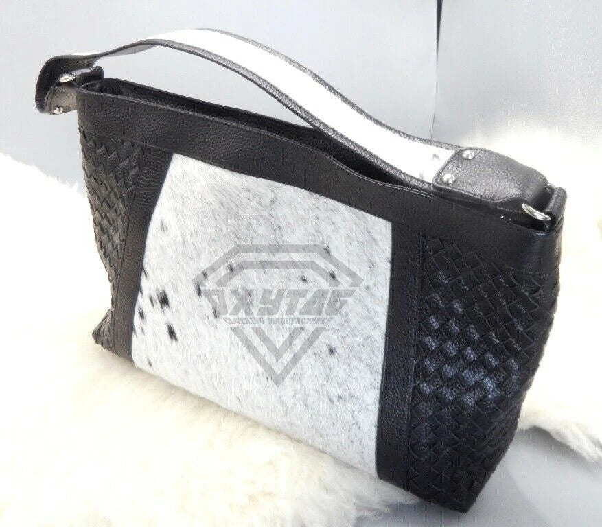 Luxury designer shoulder bag in black woven leather and white cowhide fur patchwork with a sleek strap.