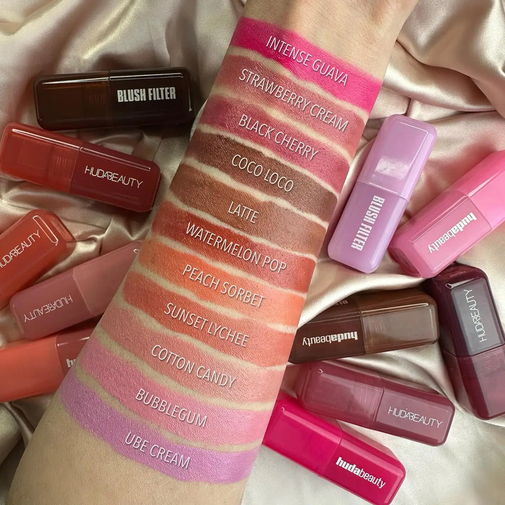 Huda Beauty Blush Filter hydrating lip and cheek stick swatches in multiple creamy, vibrant shades on arm.