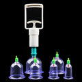 Cupping therapy set with a white hand pump and various sizes of clear plastic suction cups on a black background.