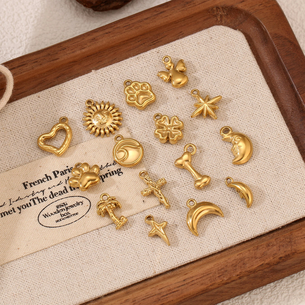 Gold stainless steel pet-themed charms including paw prints and bones for DIY pet jewelry making and craft projects.