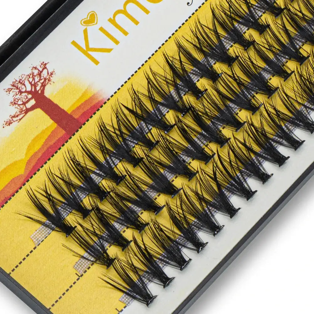 Black mink individual eyelash extension clusters in a tray, arranged for 3D Russian volume makeup effects.