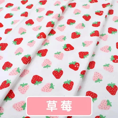 White organic knit jersey fabric with a repeating pattern of red and light pink strawberries for baby garments.