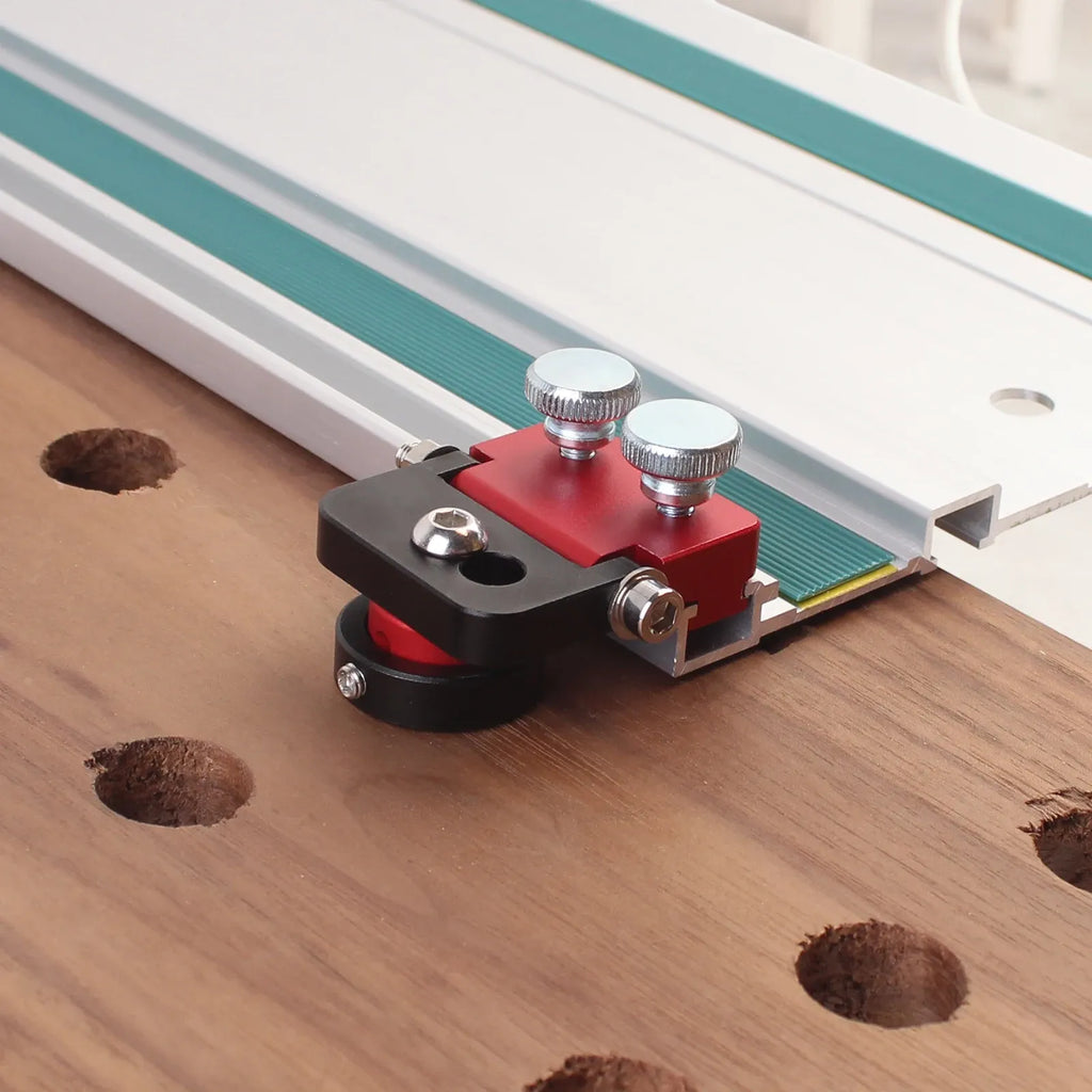 Track saw guide hinge dog clamp on wood, red plate, black base, two top bolts