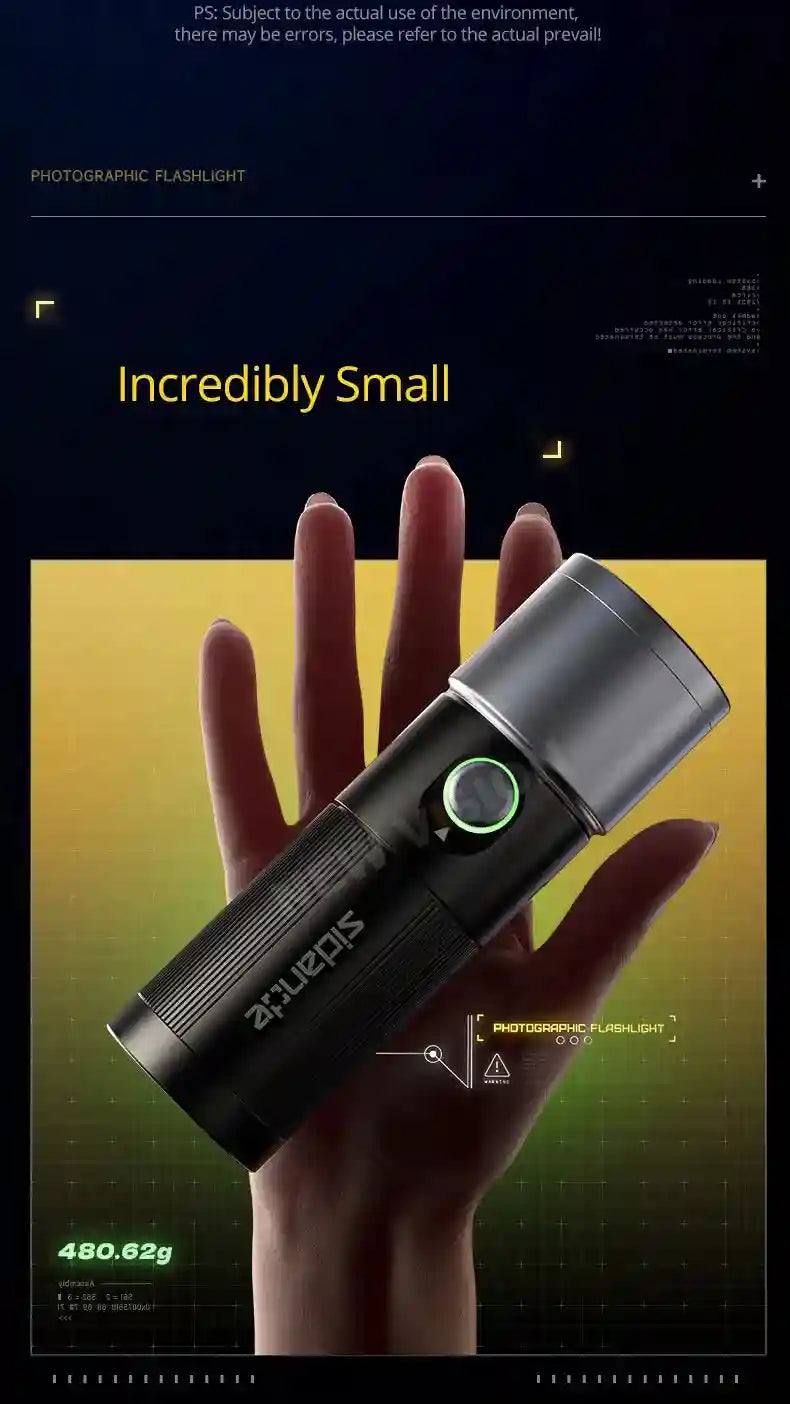 Compact black metal LED photographic flashlight with a glowing green button, held in a palm for scale.