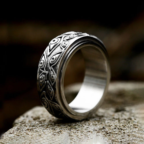 Tidesmit silver stainless steel spinner ring featuring an engraved pattern of repeating demon eyes on a textured band.