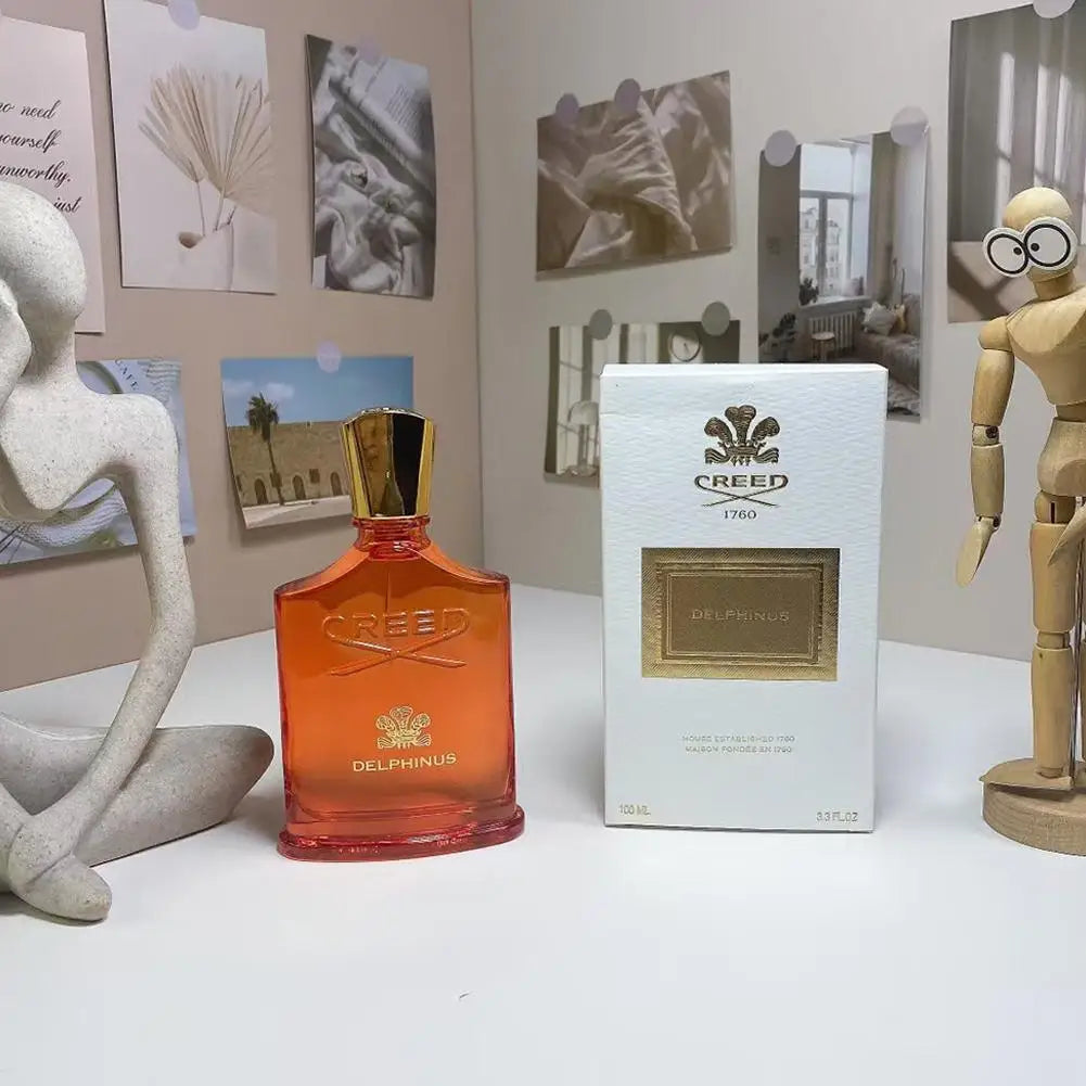 Creed Delphinus unisex EDP in orange glass bottle with gold cap and white perfume box. Luxury fragrance, 100ml spray.