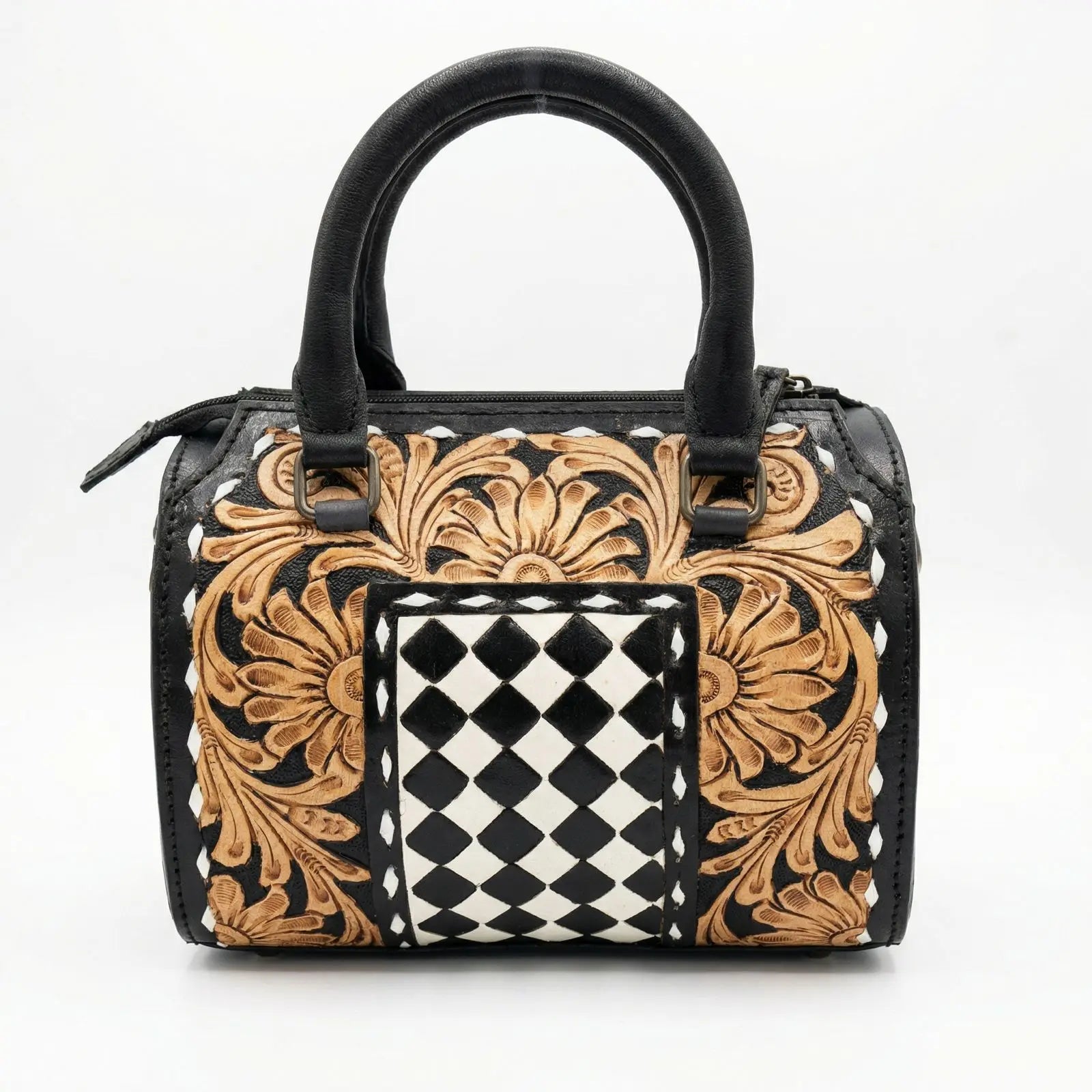 Black and tan leather luxury trunk bag with hand-tooled floral carving and a center checkered pattern.