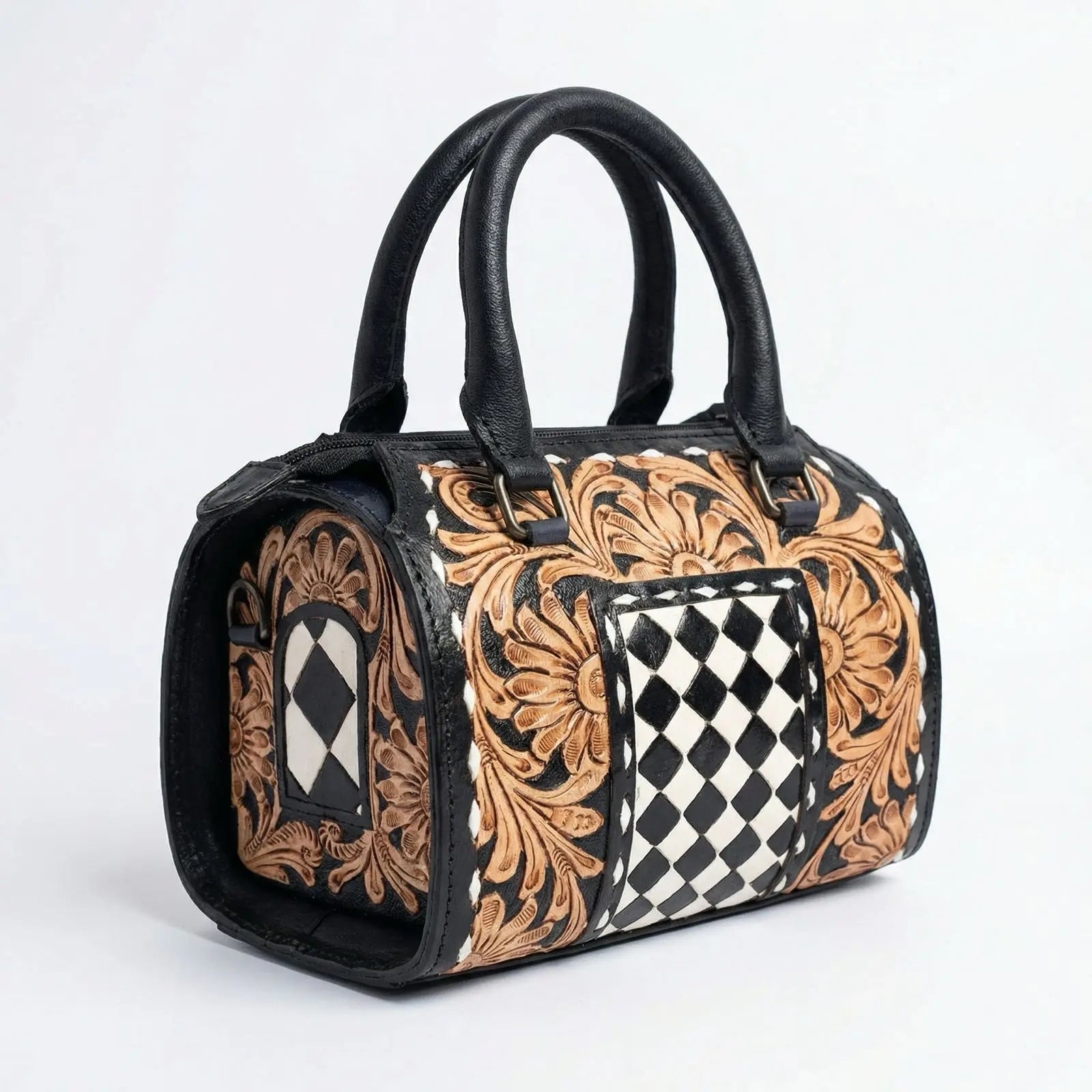 Luxury hand-tooled leather duffel trunk with floral carvings and a black and white checkered pattern.