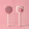 Pink self-cleaning cat grooming brush with stainless steel bristles for effective pet hair removal and detangling.
