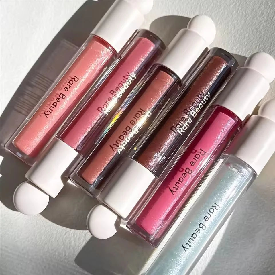 Rare Beauty Soft Pinch Tinted Lip Oil collection in various pink, nude, and red shades with a glossy, hydrating finish.