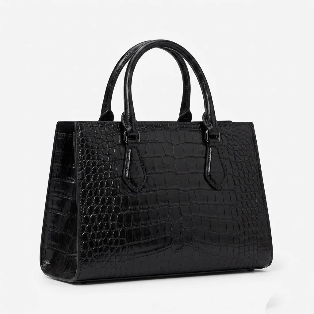 Black alligator embossed leather vintage designer handbag with top handles and structured luxury silhouette.