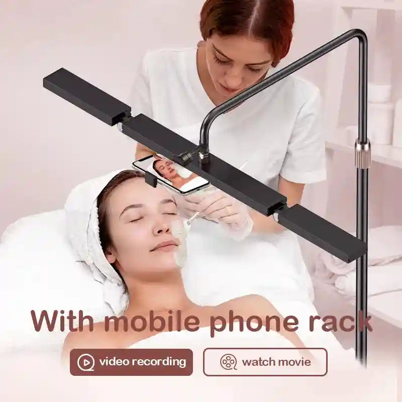 Black adjustable floor lamp with a horizontal light bar and integrated phone mount for filming beauty treatments.