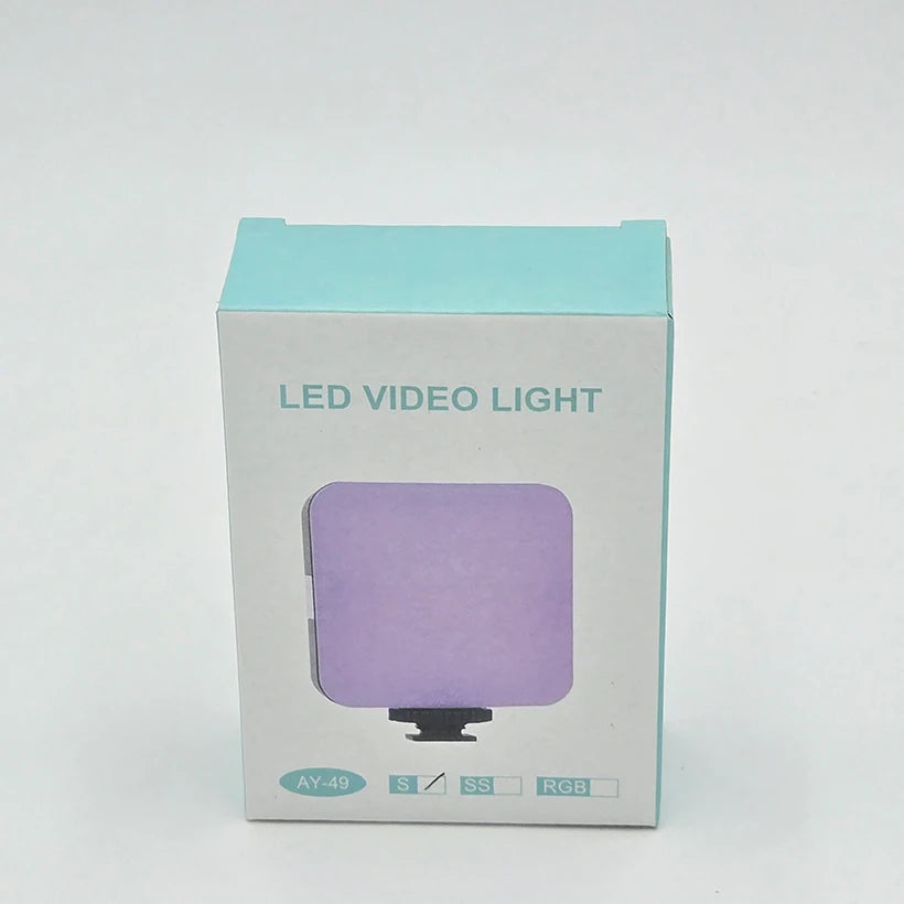 AY-49 square RGB LED video light in packaging, designed for camera or smartphone mounting.