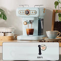 Petrus retro blue espresso machine with pressure gauge, portafilter, and steam wand brewing coffee on a wooden counter.