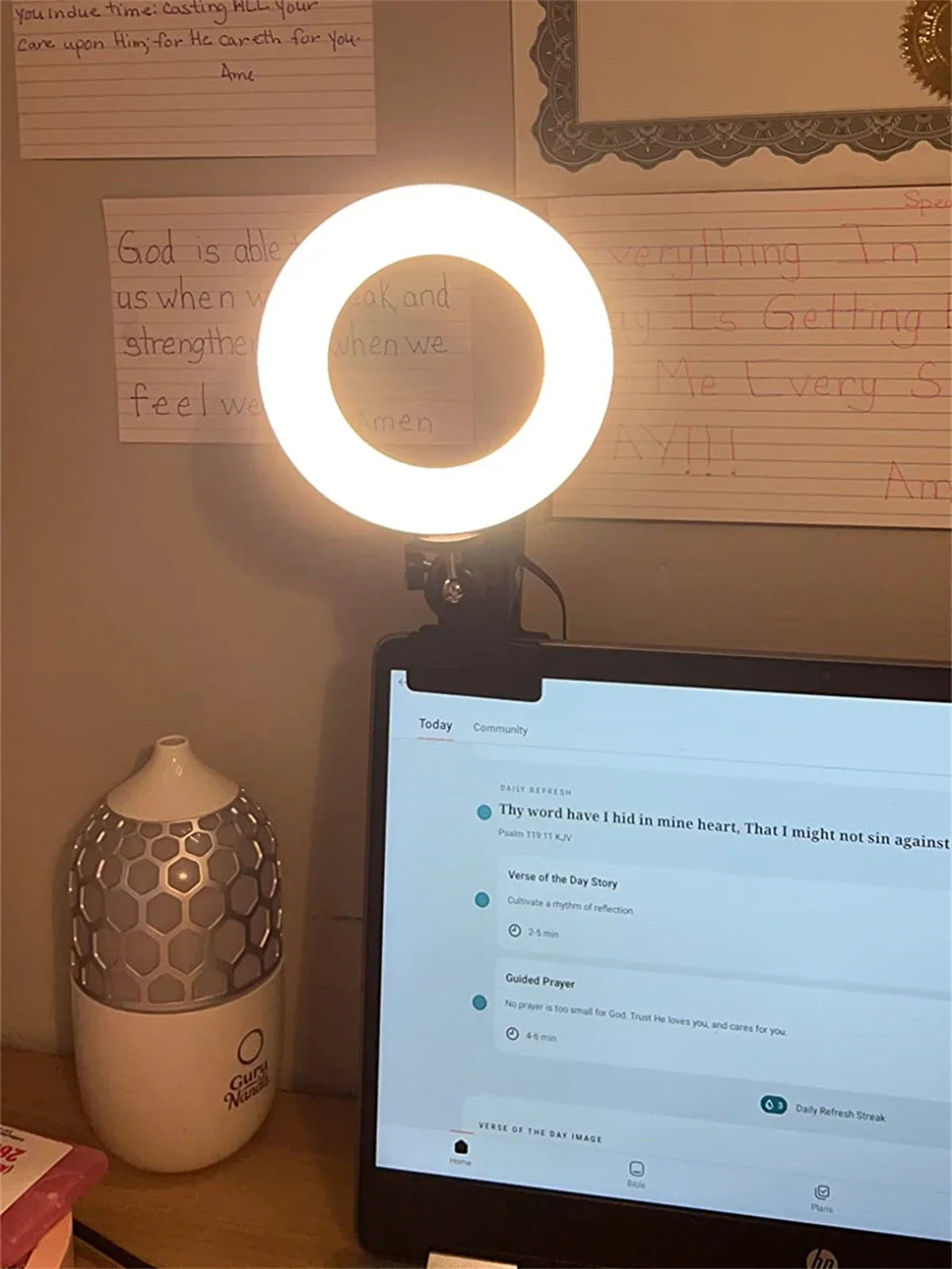 Small circular LED ring light clipped to the top of a laptop screen to provide illumination for video calls.