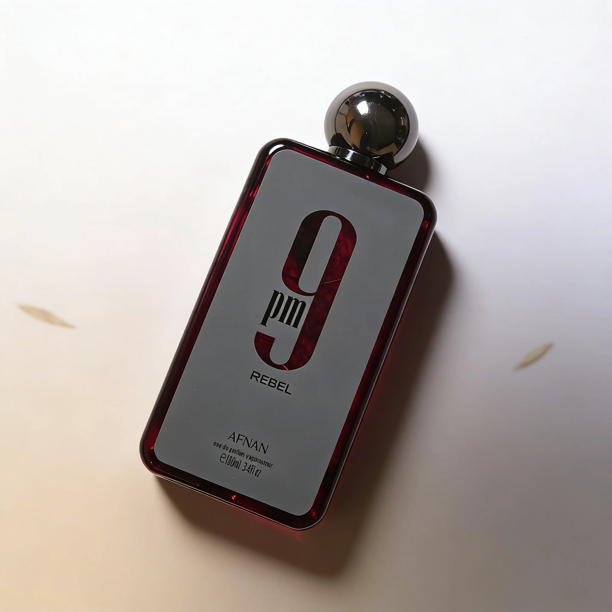 Afnan 9pm Rebel EDP 3.4oz: A woody, long-lasting masculine fragrance in a sleek rectangular bottle with round cap.